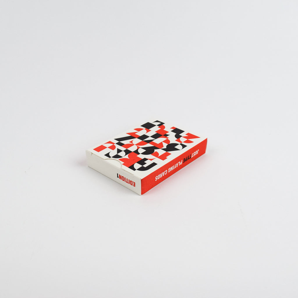 Small box of playing cards with geometric pattern on a light gray background