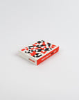 Small box of playing cards with geometric pattern on a light gray background