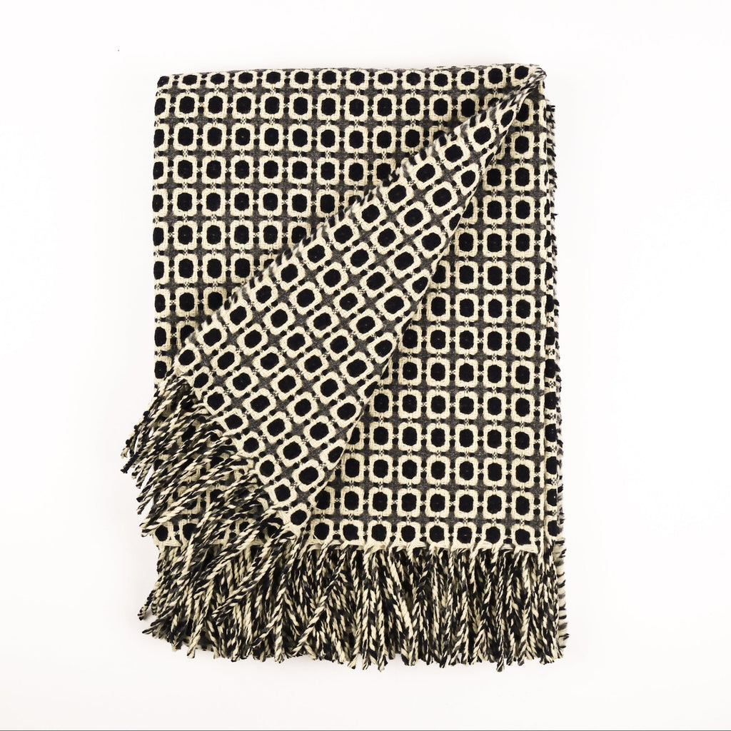 Patterned throw blanket with fringe on a white background