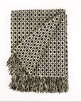 Patterned throw blanket with fringe on a white background