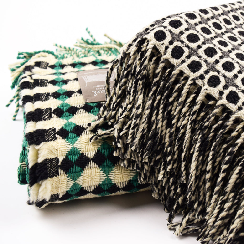 Two patterned blankets with tassels on a white background