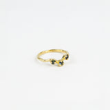 Gold ring with three blue gemstones on a white background