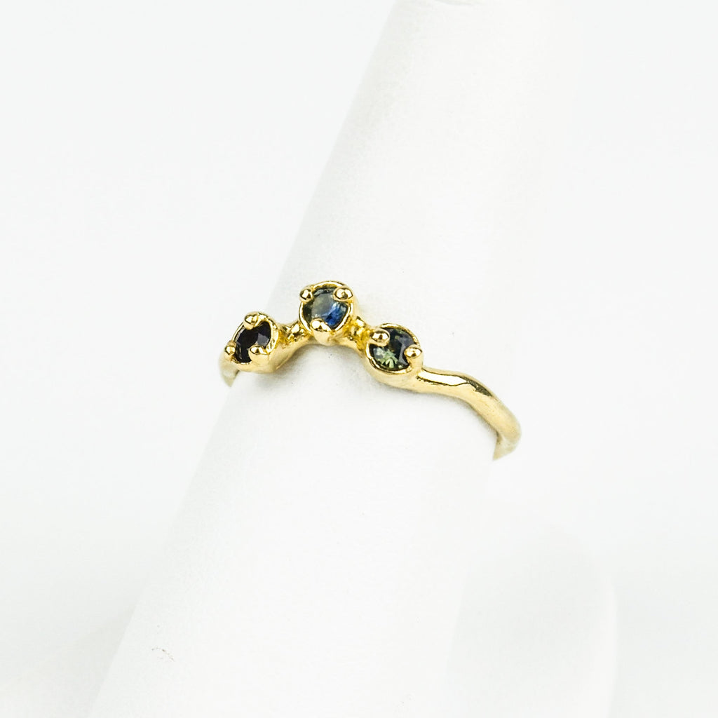 Gold ring with embedded stones on a white background