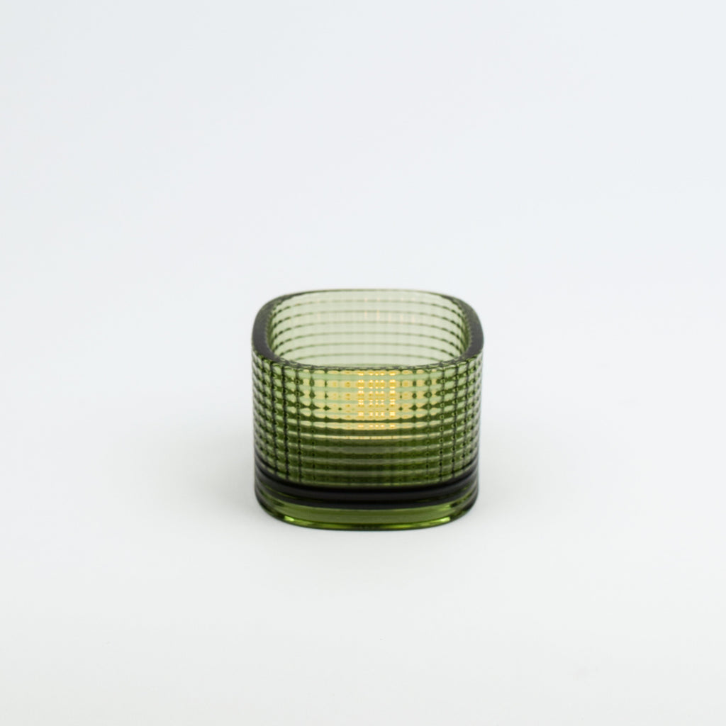 Green glass candle holder on a white background
