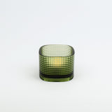 Green glass candle holder on a white background