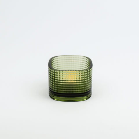 Green glass candle holder on a white background