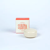 A small jar of Suavina lip balm next to its packaging box, with the brand name 'SUAVINA' displayed prominently on both the box and the jar.