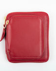 A red leather wallet with gold toned metal hardware and a zipper around the exterior pocket.