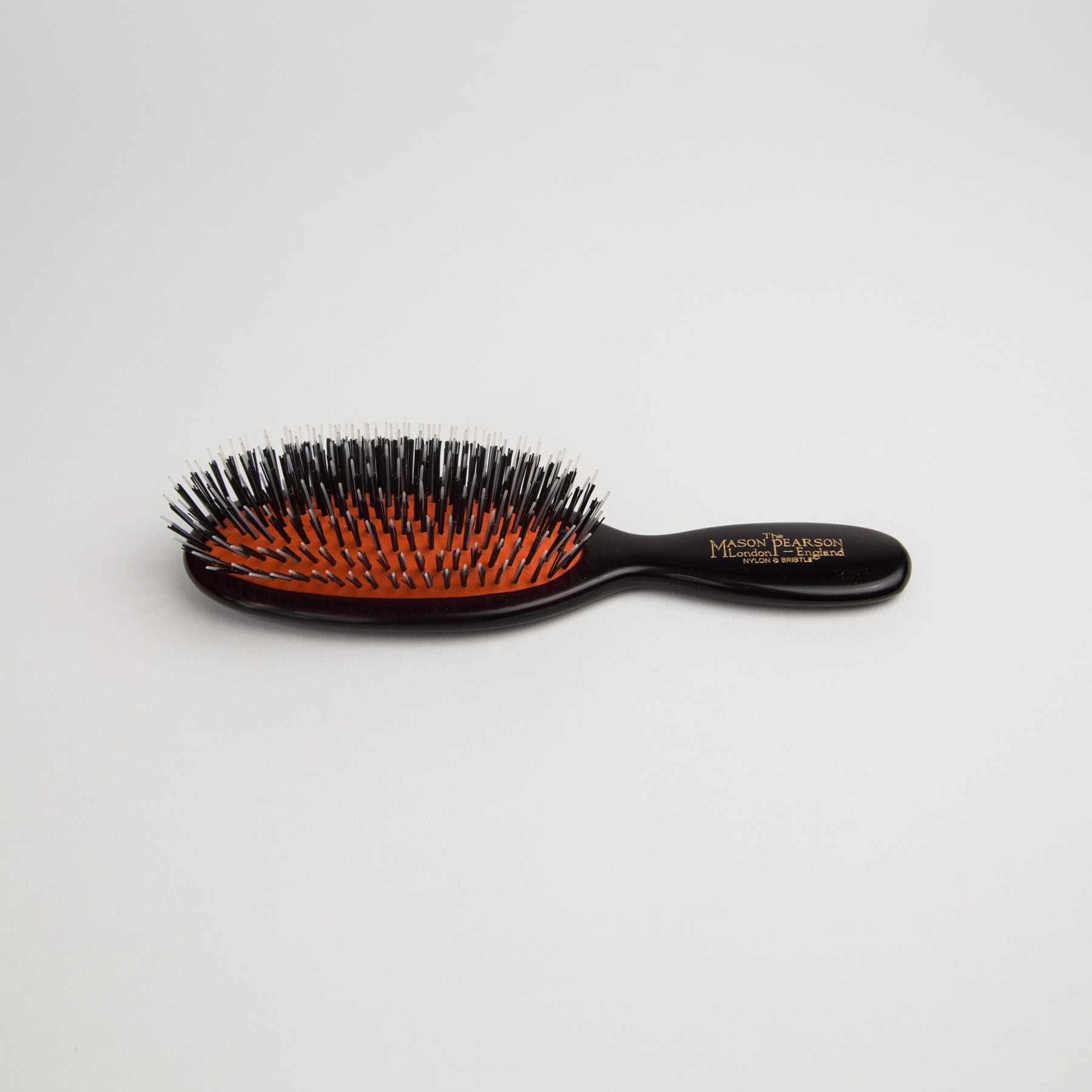 A mason pearson pocket size hairbrush with mixed bristle on a white background.